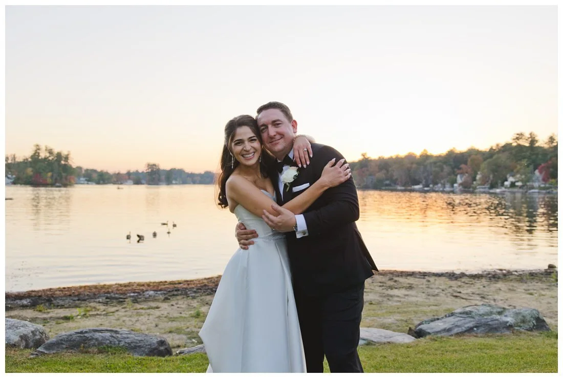 rachel and nick hug and smile with sunset behind them