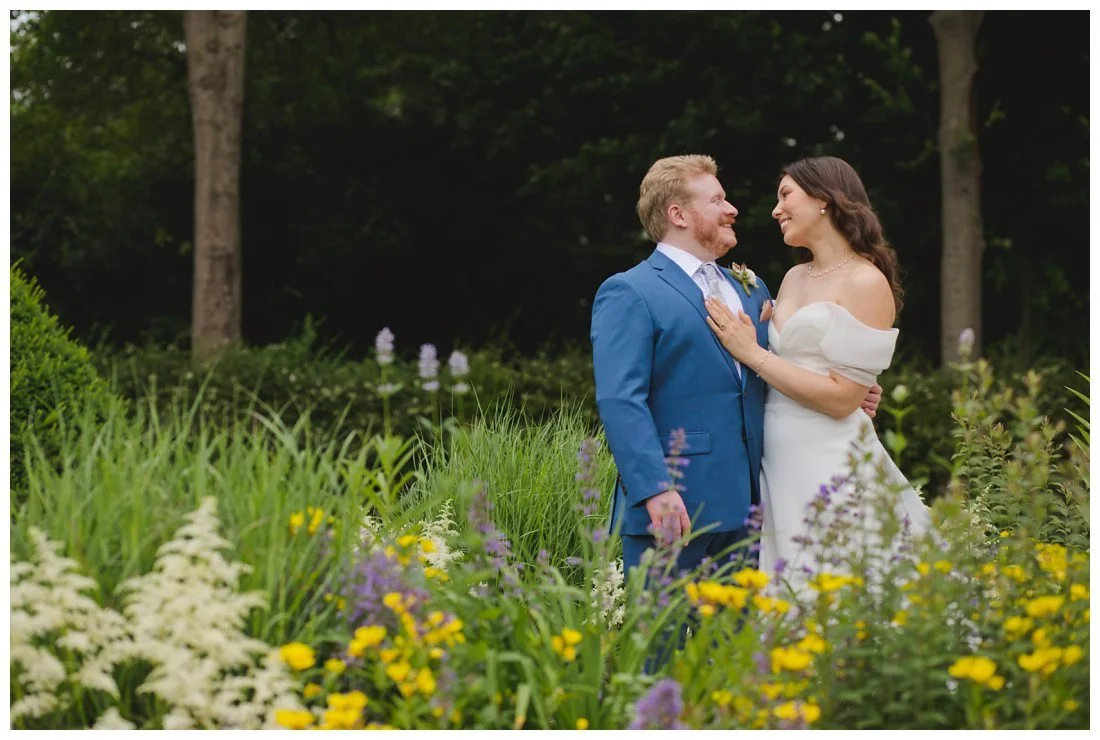 wedding photos framed by flowers in the garden and dark forest behind