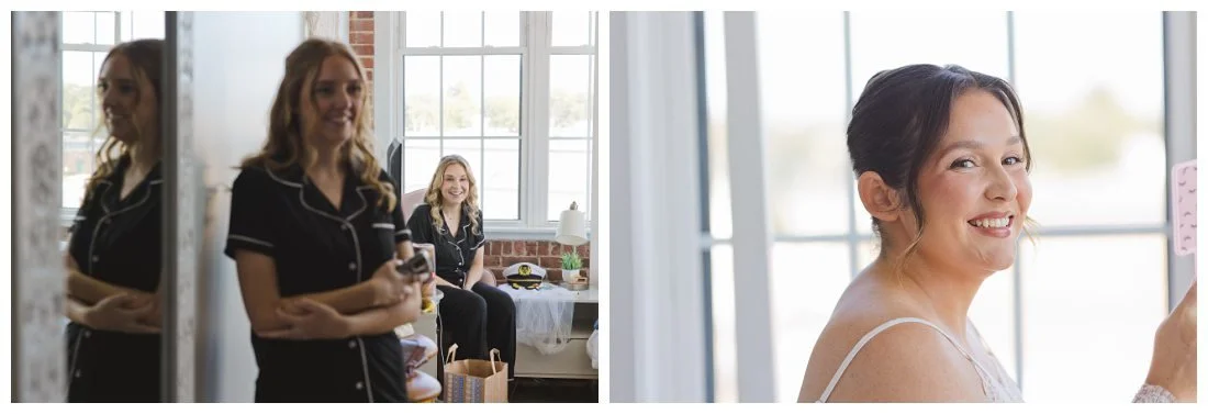 bride looks in mirror happily at her wedding makeup and bridesmaids in their pjs smile behind her