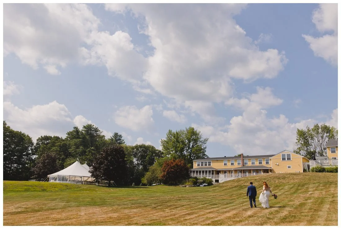 wide angle photo of the grounds at the westbrook inn with tent and the inn and lawn