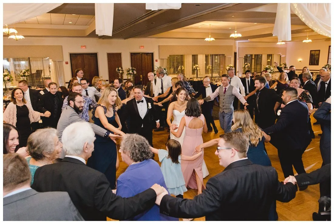 the hora begins with rachel and her family and wedding party in the center circle