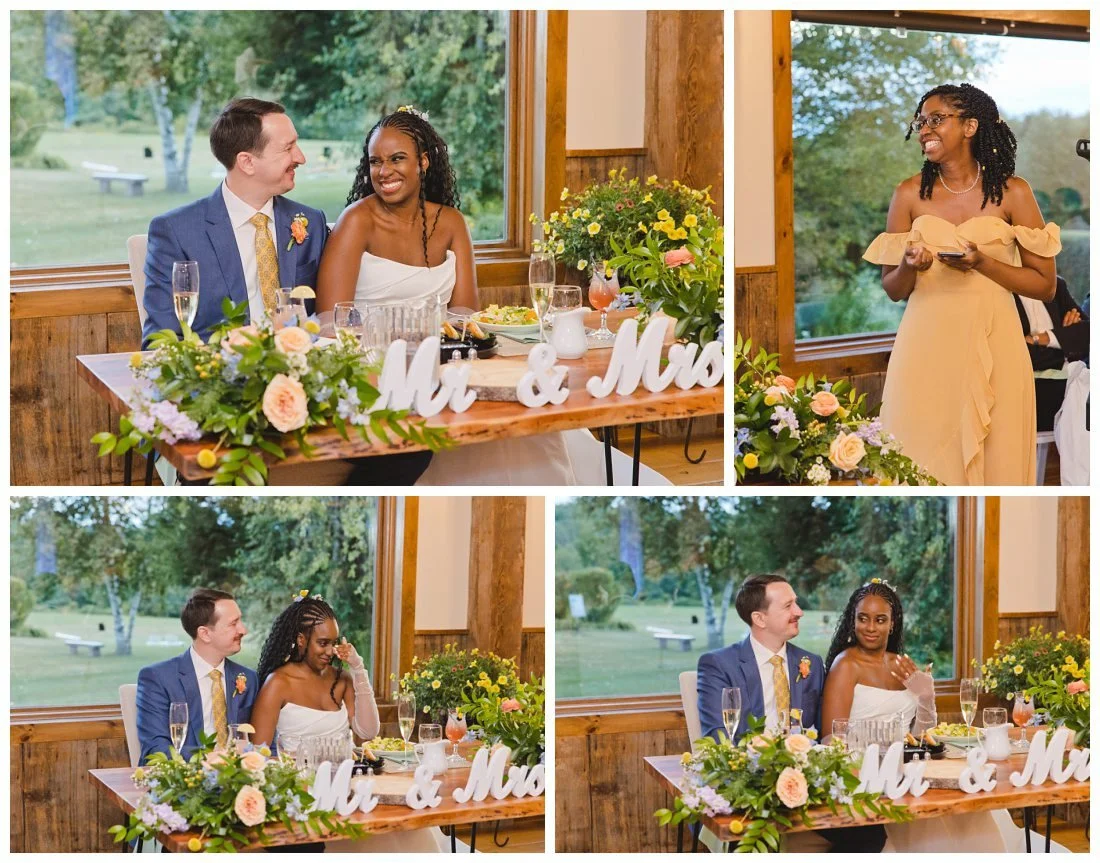 bride's sister gives a funny toast and the couple laughs, their table has mr. and mrs. signs and florals, sitting in front of big window with the fields of dell lea behind them