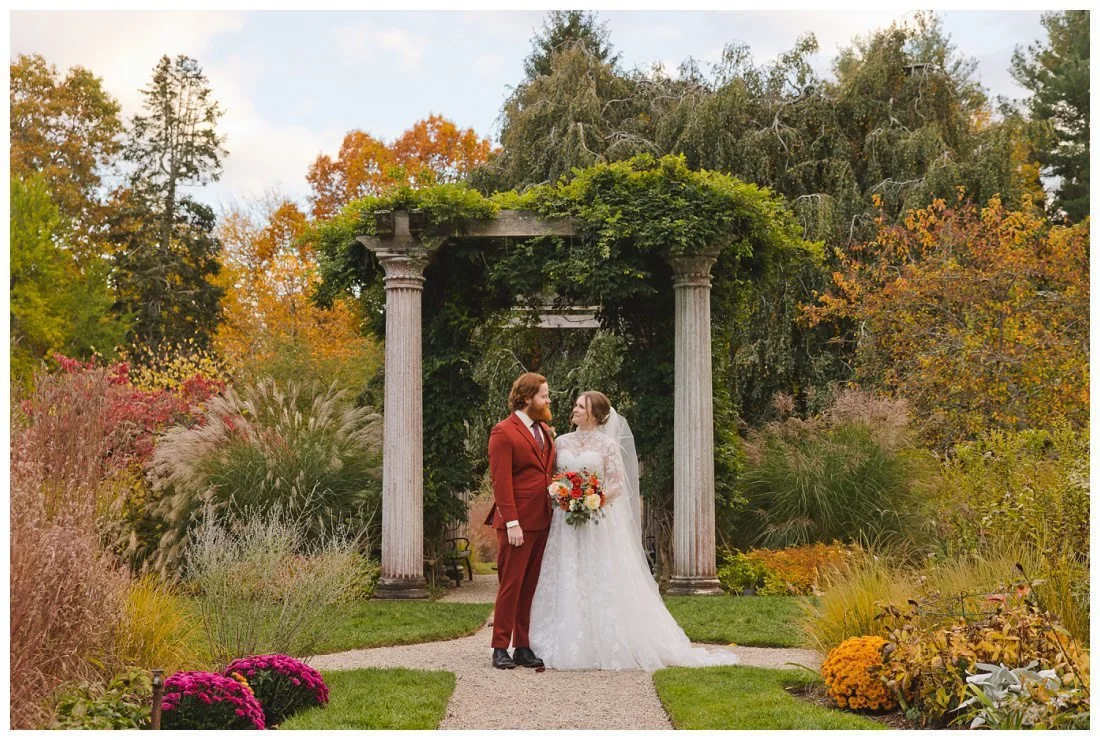 bride and groom in front of the arbor in the garden at glen magna