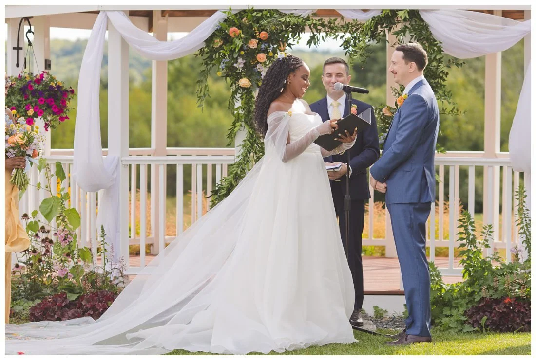 bride reads her vows in front of gazebo at dell lea with mountains in the background