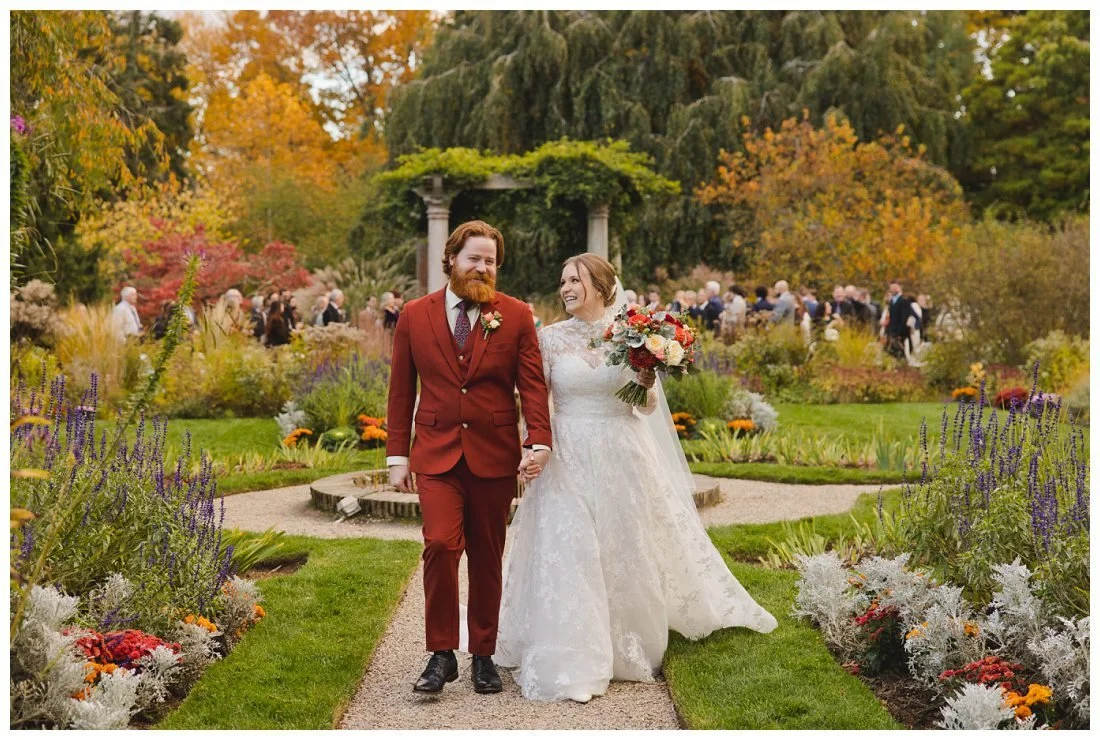 bride and groom come back down the aisle after their wedding ceremony at glen magna farms, laughing and looking at each other