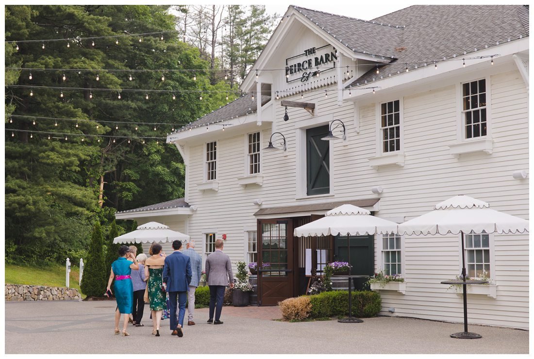 guests go into peirce barn for cocktail hour, big white building with cafe lights strung up outside