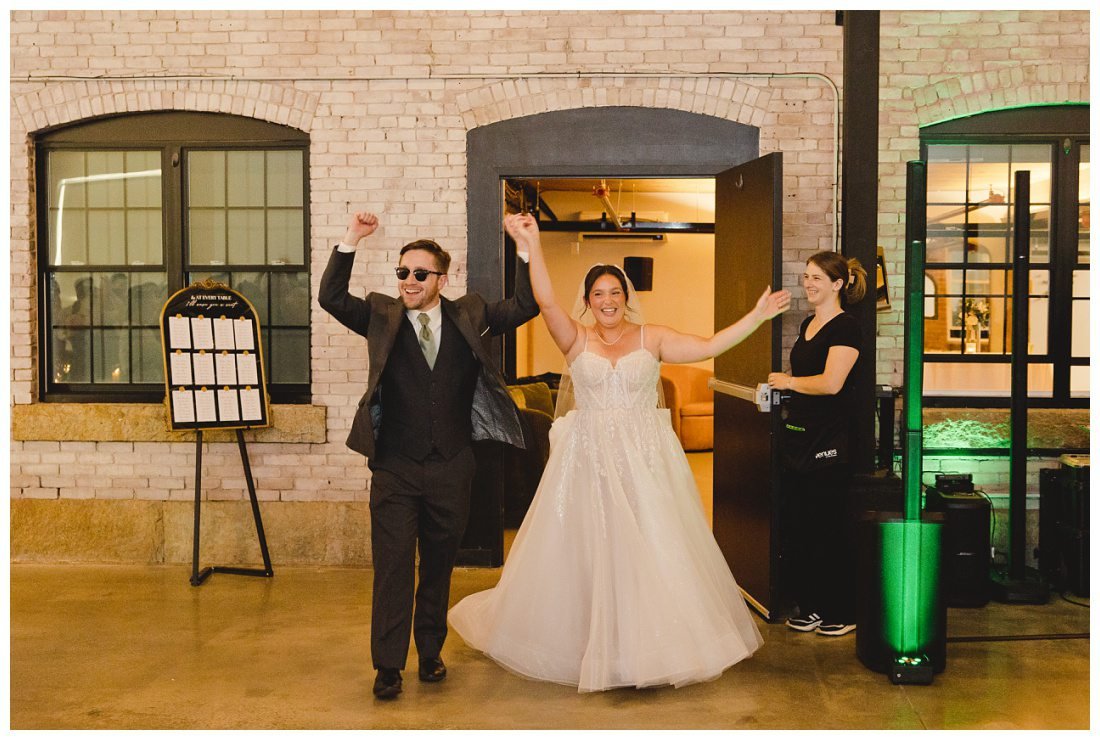 nick and natalie arrive into their reception cheering