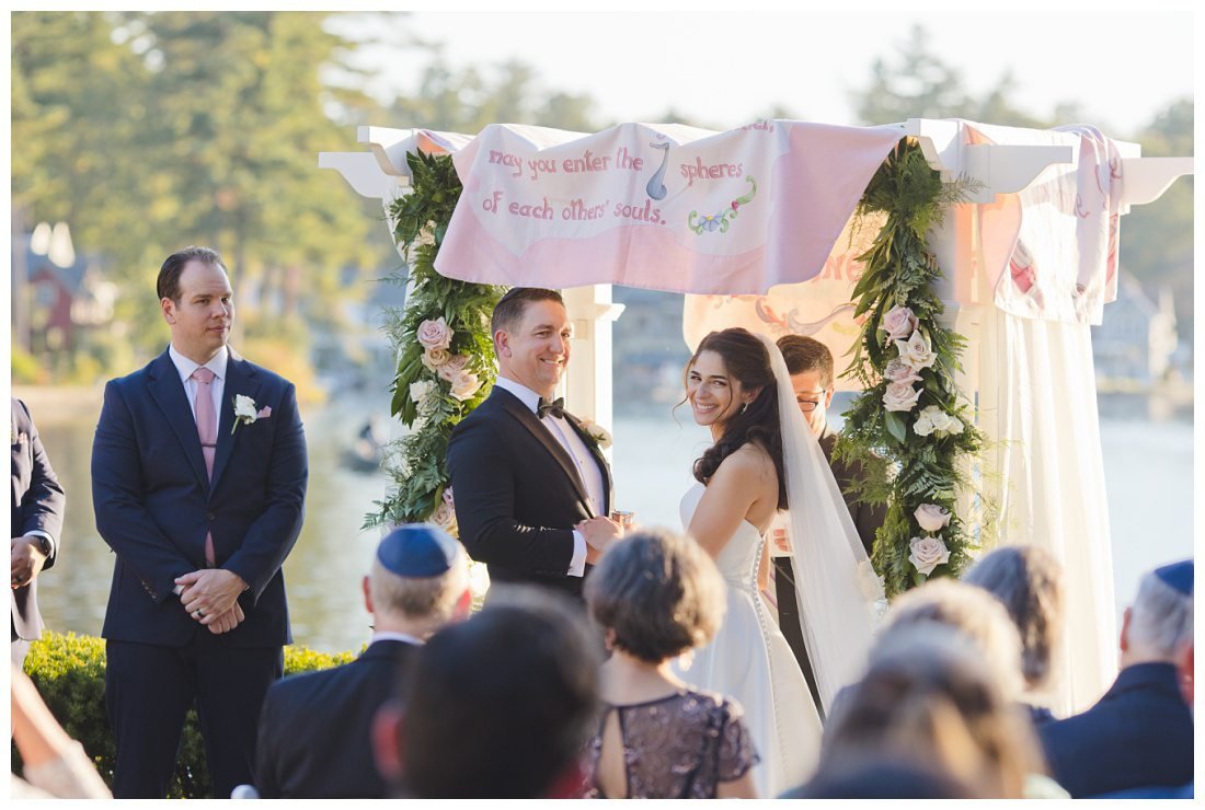 bride and groom look back at bride's parents during wedding ceremony