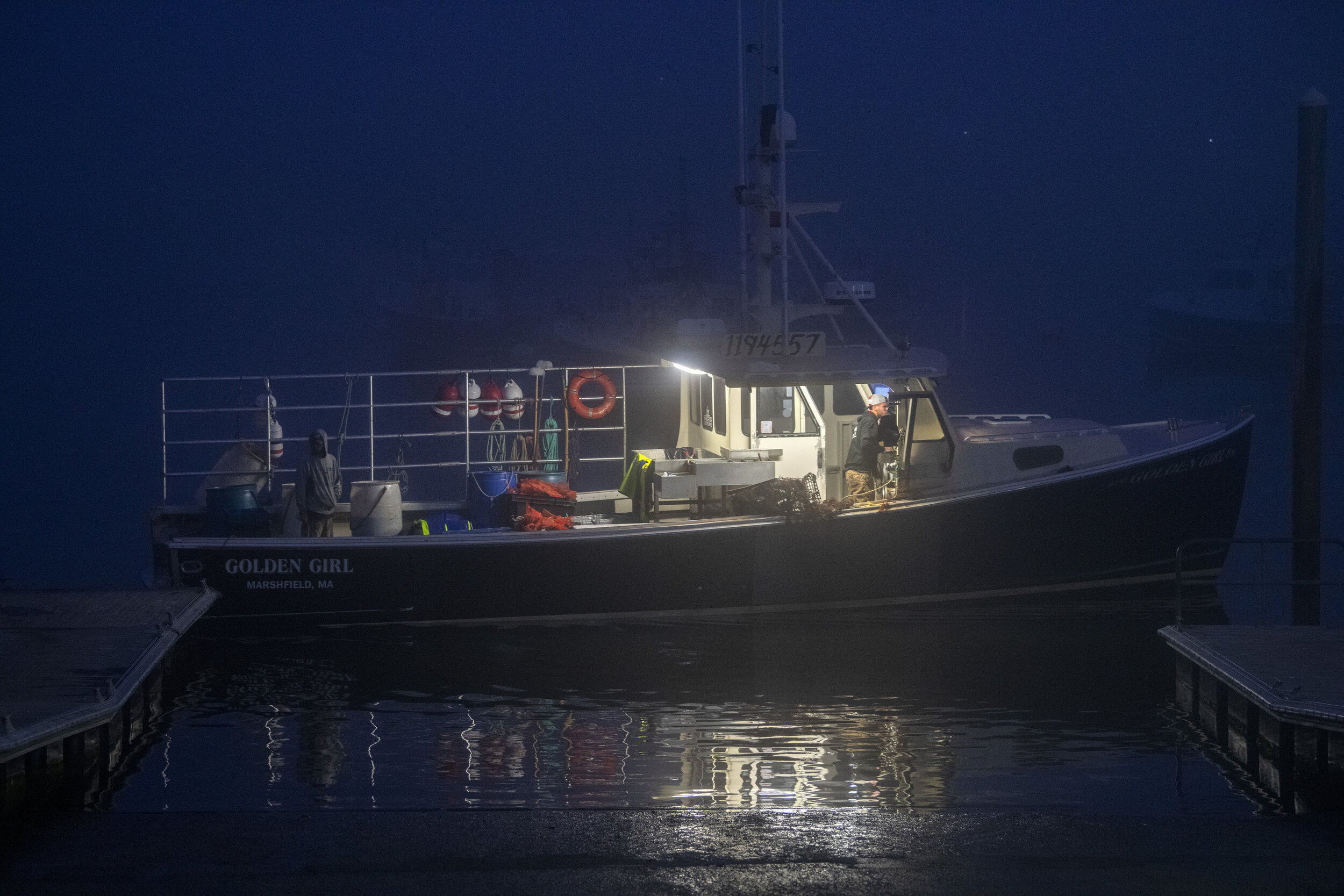 The lobster boat, Golden Girl, returns to Green Harbor at night through a dense fog in Marshfield, Mass. One of the biggest dangers of fishing in New England is one of the most obvious, weather and sea conditions. The harbor is often engulfed in fog