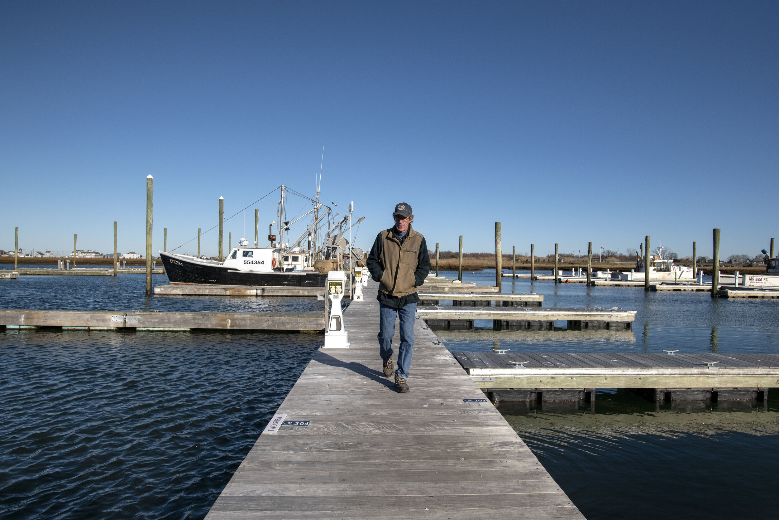 Tim Barrett walks past empty slips as he leaves his boat in Green Harbor, Mass. With the current state of the groundfish populations and subsequent regulations, and a two month winter closure for lobstermen to protect Right Whale calving, many fishe