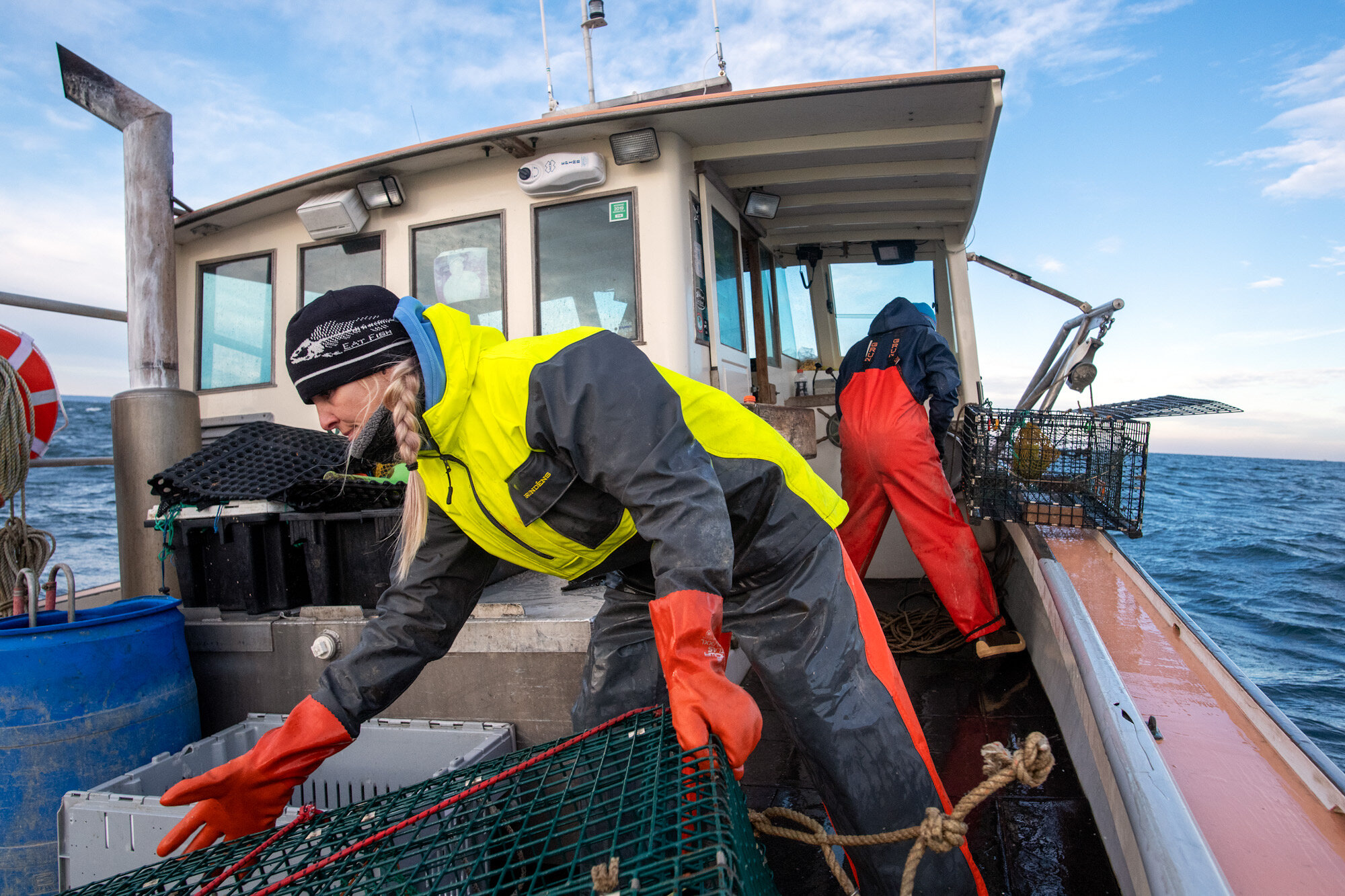 Cara Delaney, a sternman on the lobster boat, Kestrel, stacks an empty trap after pulling it from Cape Cod Bay. Since 2016, the bay has been ordered closed from lobstering between February and April by NOAA to protect the endangered Right Whale from