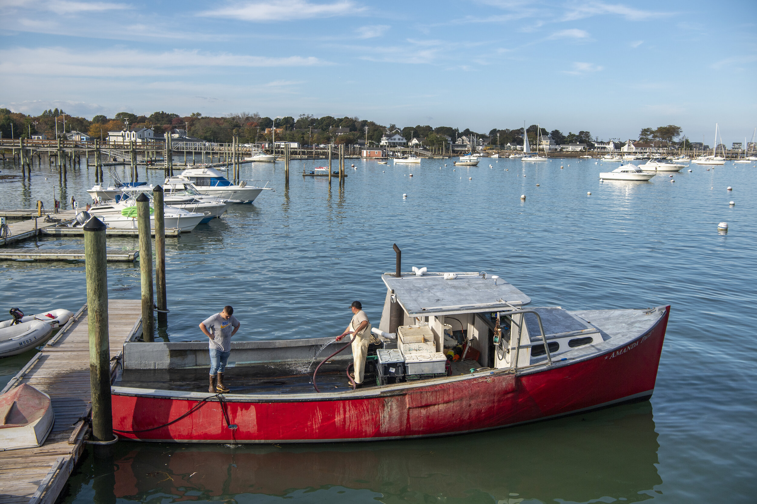 Jonathon Dauphinee, right, talks with his son, Jared, as he washes down his lobster boat, Amanda Page. What lobstering means to Jonathon and his generation has changed for Jared’s generation. Instead of lobstering, Jared is leaning toward another li