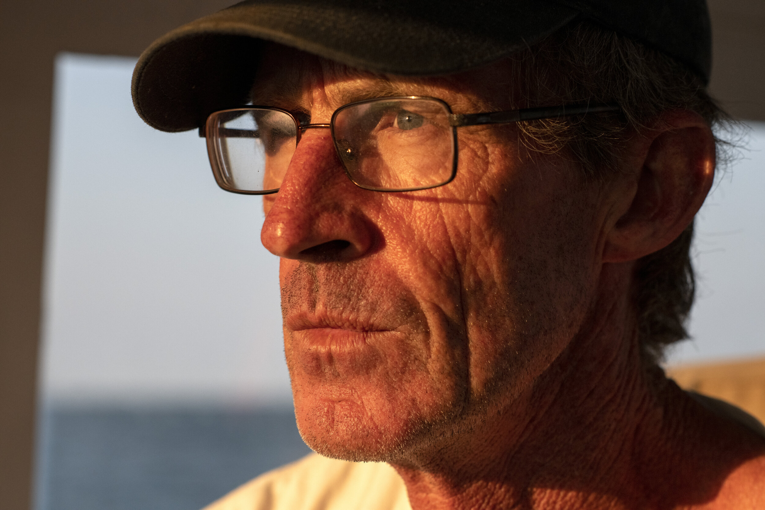 Tim Barrett gazes out over the horizon as the summer sun rises above Nantucket Sound. Trawling alone means awaking in the dead of night, hours on end of hard work and also hours with no one on board to talk to. But the unobstructed view of a rising