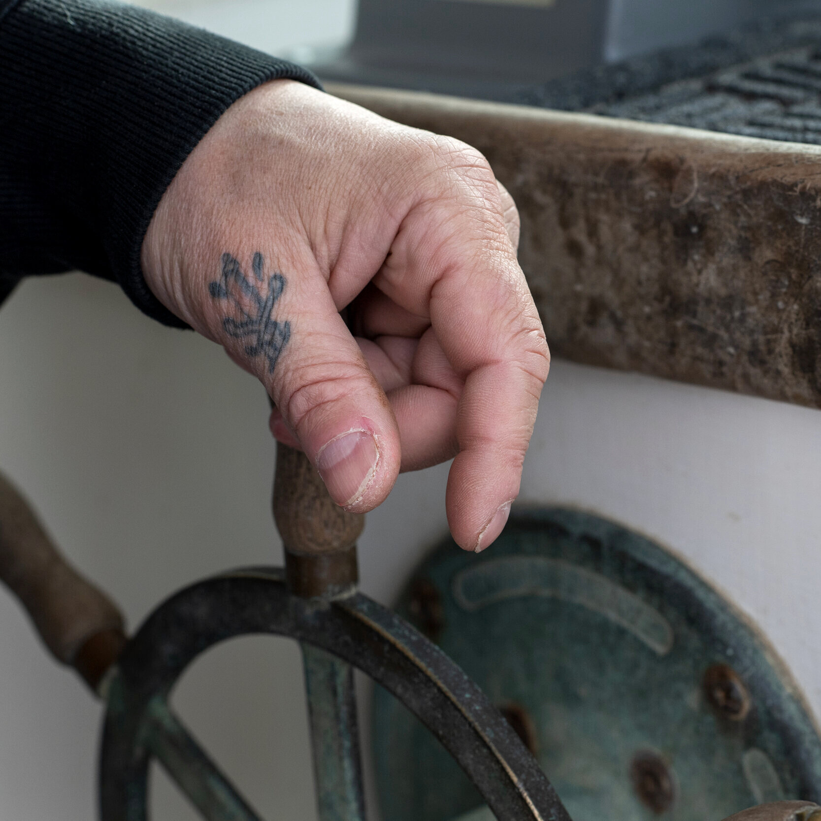 With a tattoo of a dagger on his thumb and a gentle grasp on the wheel, Peter Mason steers the Kestrel through Cape Cod Bay to Plymouth to be dry docked for painting during the lobster closure period. Wind whipped skin and tattoos are a common sight