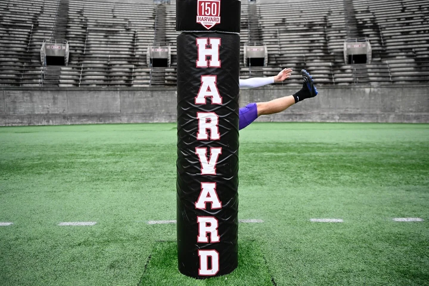  A University of St. Thomas player stretches before their debut game against the Harvard Crimson at Harvard Stadium    