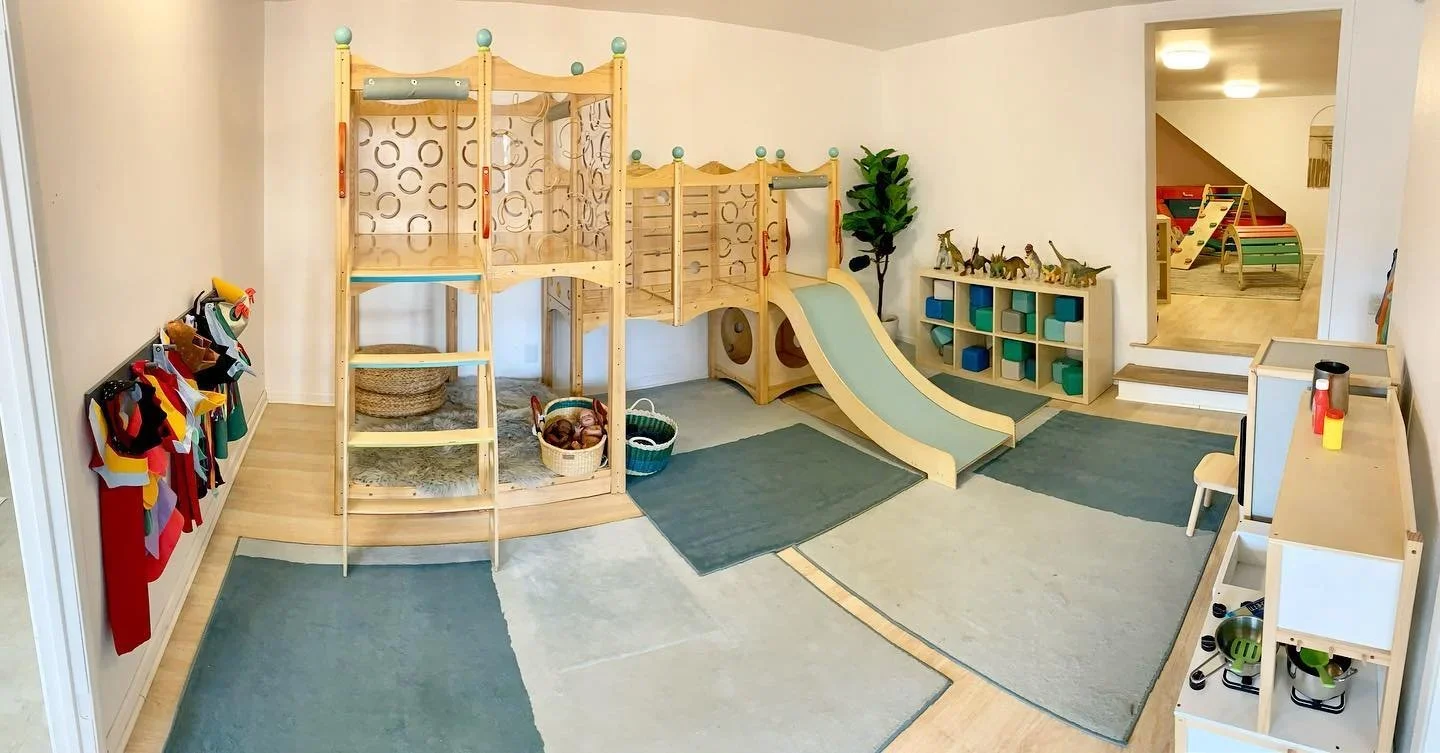 A bright and engaging indoor-outdoor playground area at PlayLab Eagle Rock, featuring colorful play structures for babies and toddlers aged 5 and under.