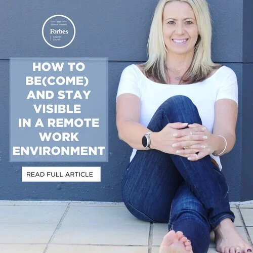 Woman sitting barefoot on the ground with legs crossed, smiling, and leaning against a blue wall next to a sign that says, "How to Become and Stay Visible in a Remote Work Environment."