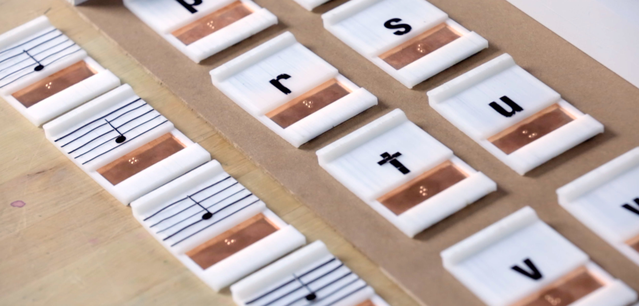 Music and letter tiles displaying high contrast, large print, and sturdy braille