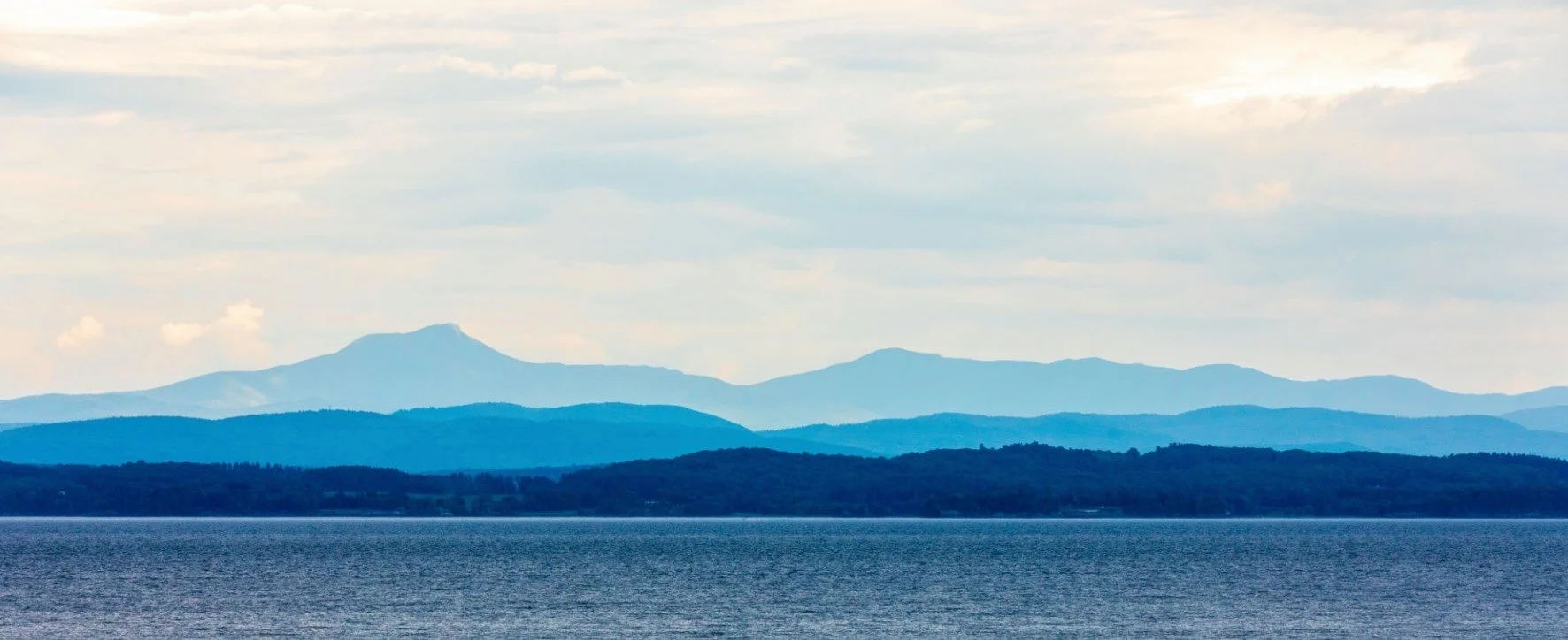 blue-tinged photo of Lake Champlain and the Green Mountains
