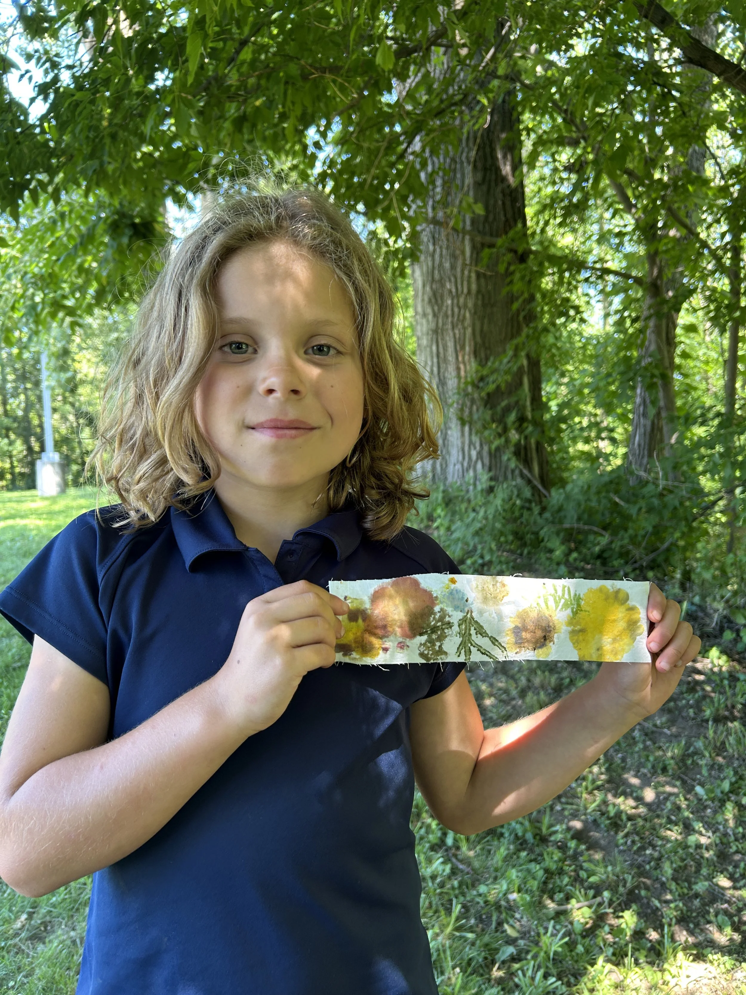 camper holding up a handmade bookmark