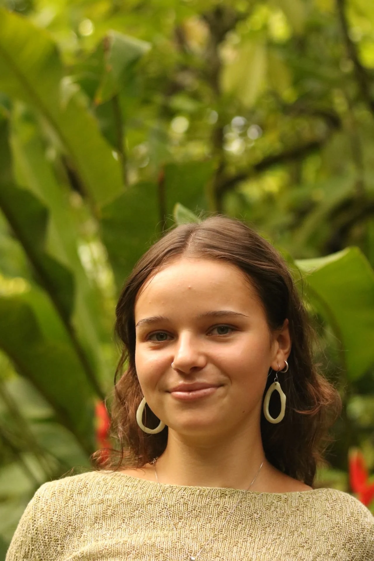 Maggie, facing the camea with a tropical forest in the background