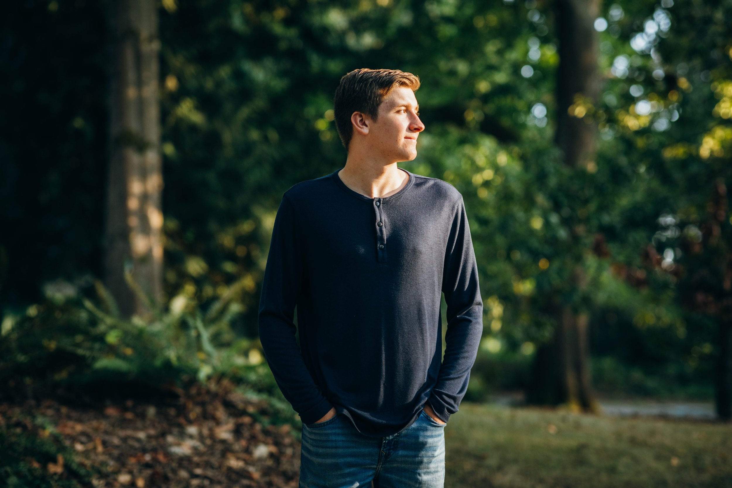 senior boy standing in PNW forest