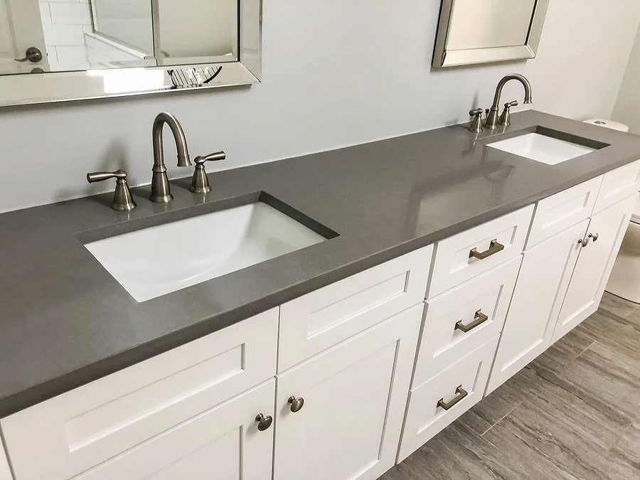 Modern bathroom vanity with gray quartz countertop, double sinks, and white cabinetry for a clean, durable bathroom upgrade.