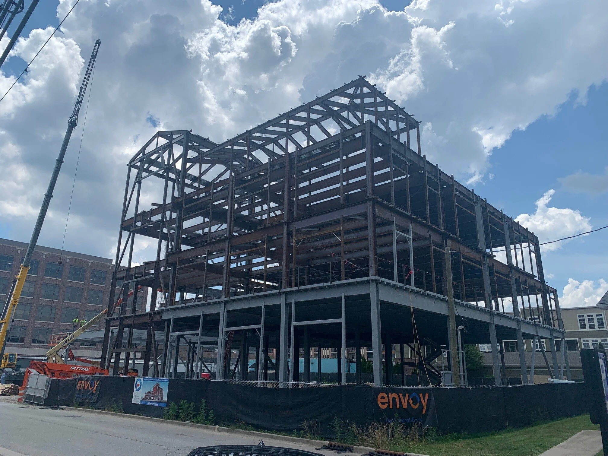 Steel building frame under erection with a crane on site