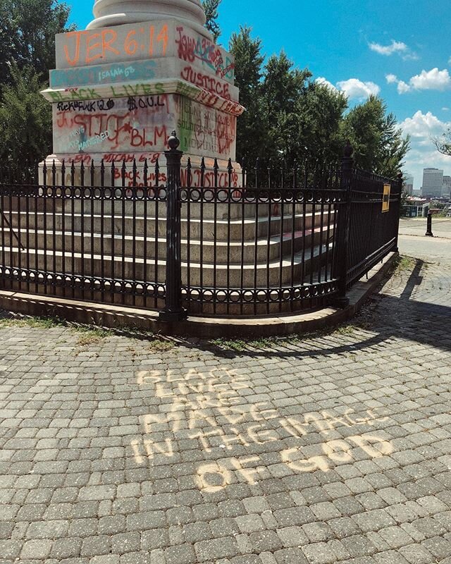 Black lives matter. ID: this is an image of a contextualized confederate monument that includes spray painted art depicting the Black Lives Matter movement. Someone wrote &ldquo;Black lives are made in the image of God&rdquo; on the cobblestones in f