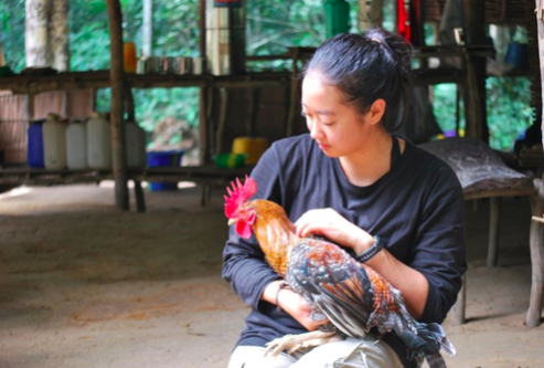Holding a chicken at a field site in Congo.