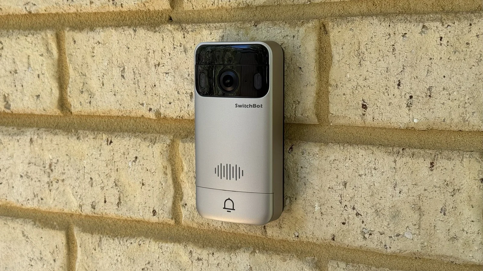 Switchbot doorbell mounted on a brick wall