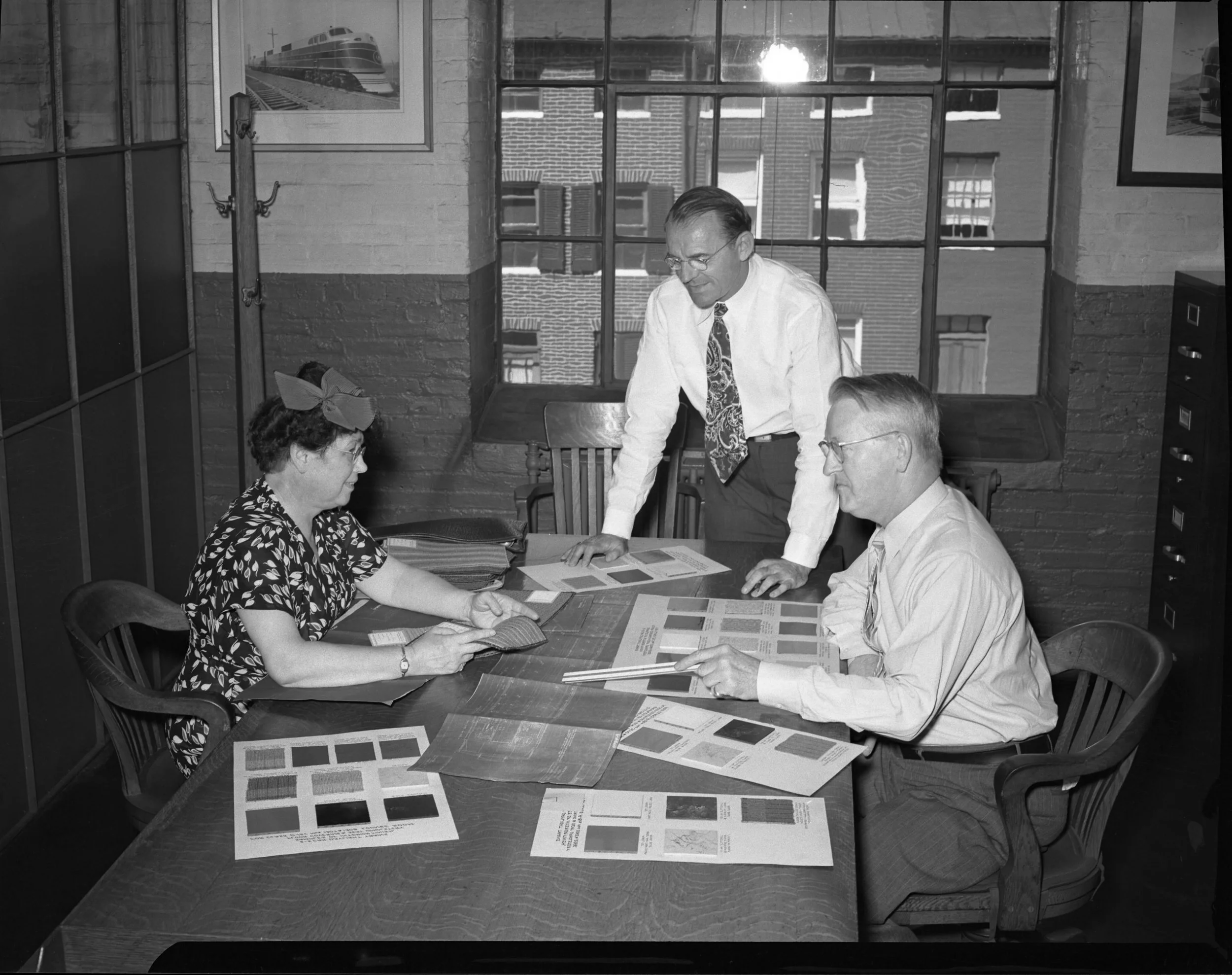 Service Engineer Olive Dennis consults with Alden B. Lawson, Assistant Engineer, Motive Power & Equipment (standing) and Frederick H. Einwaechter, Chief Engineer, Motive Power & Equipment (seated). The photograph was taken in the Mechanical Engineering Department at Mt. Clare, around 1947-1948. Photo courtesy of the B & O Railroad Museum