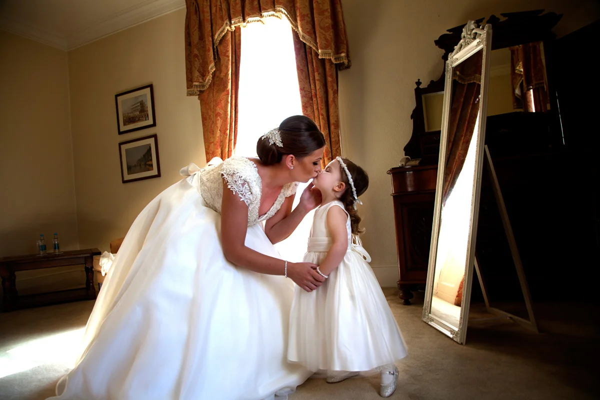 A kiss between bride and daughter at the Mulberry House, Ongar. Essex wedding