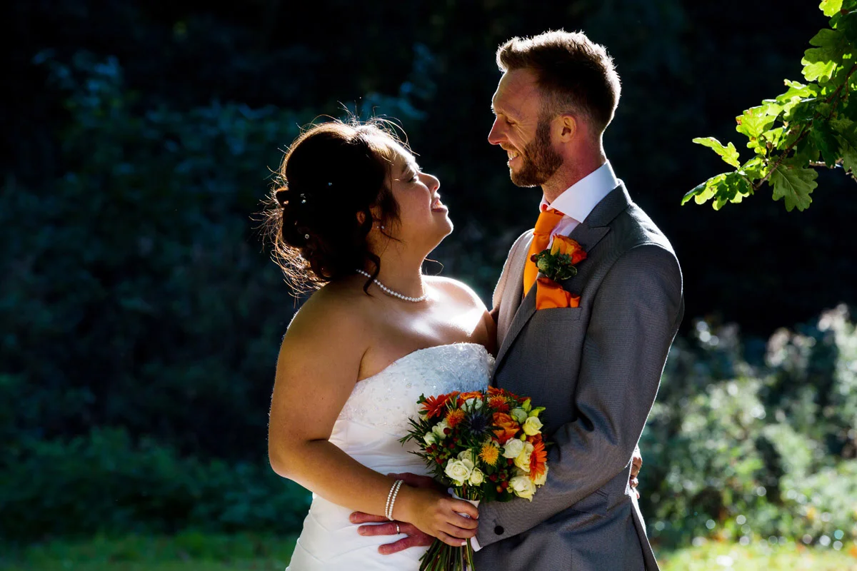 Bride and groom backlit by sunshine at their Essex wedding