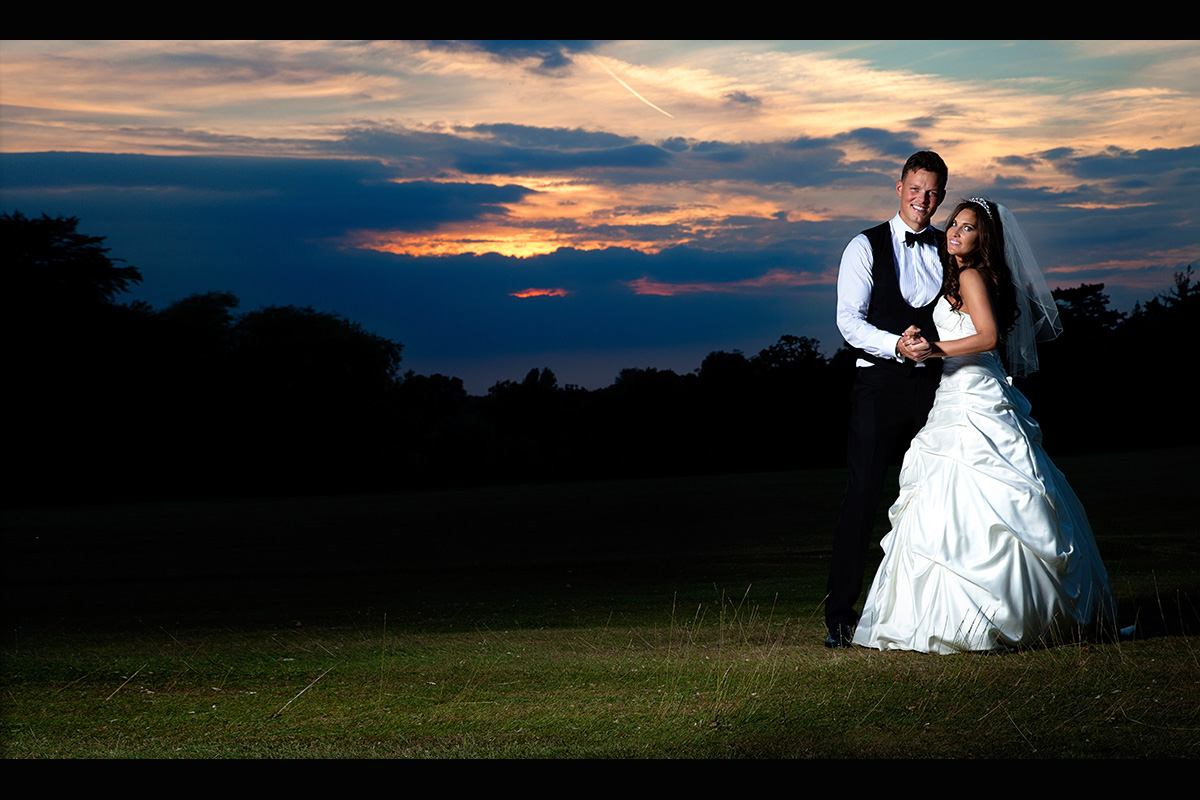Bride and groom with a sunset at stately house