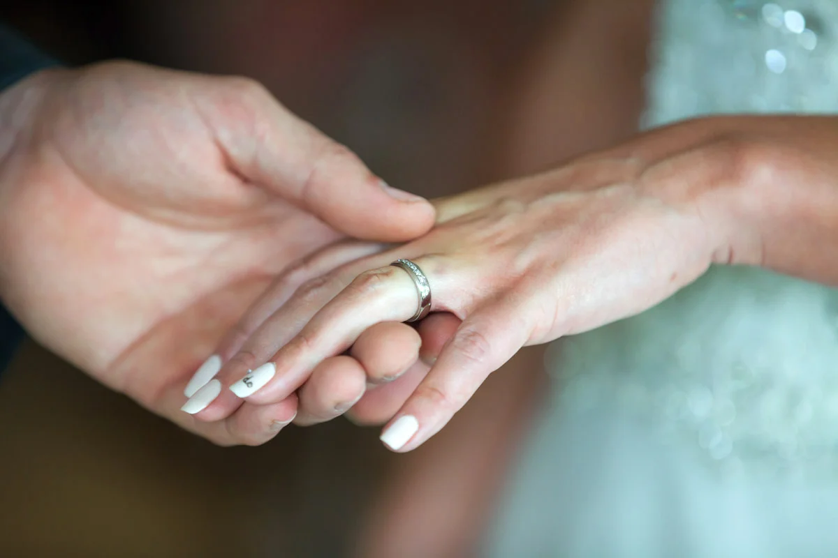 Groom placing ring on bride’s finger
