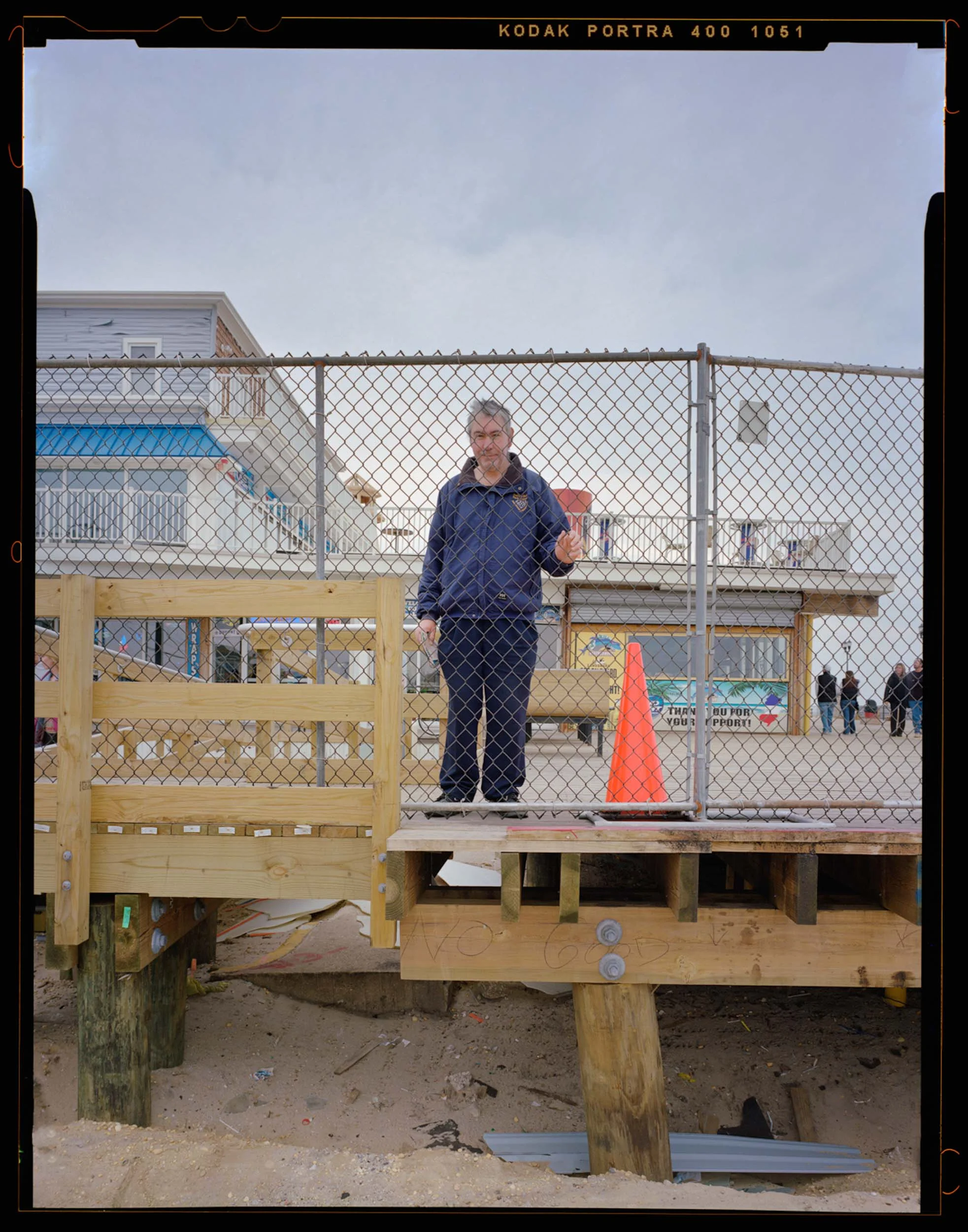 Barry, Seaside, NJ. 2014. 4x5 Shen-Hao, A Seaside native, Barry, has been a center point in my documentation of Seaside. Barry was the guy to know in Seaside, as he knew everyone and everything about the boardwalk. As soon as I connected with Barry, people took notice and became more comfortable with my project. Being so invested in the boardwalk, Barry quickly took interested in my project and helped me as much as he could. During one of our conversations, Barry mentioned his mom always wanted a photograph of him on his second home, the boardwalk. Without hesitation, I asked if I could take his picture. Barry asked me what he should do in the photo, and I told him to just be himself. He grabbed a hold of the fence while I was framing the picture under the dark cloth and it was just perfect. When I returned the next month I printed his mother this photo.