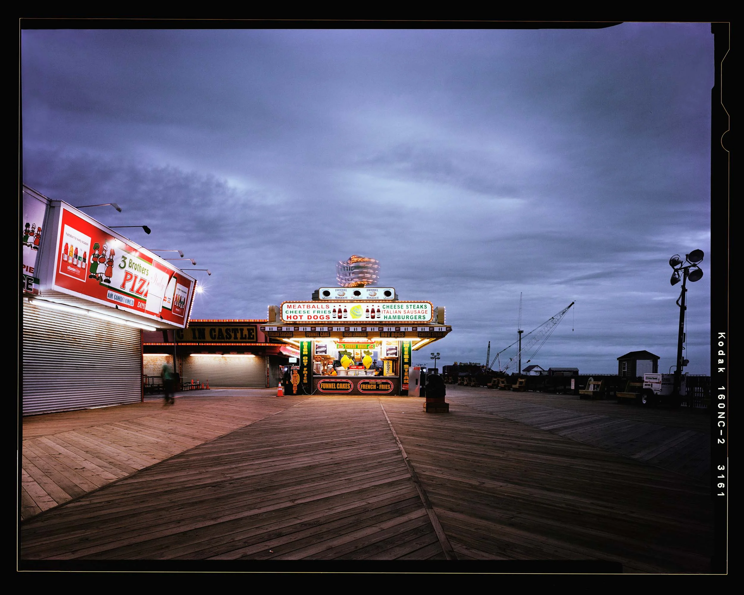 Midway, Seaside, NJ. 2012. 4x5 Shen Hao. This is the photograph that started the whole project. I love this photograph. The sunset light fading combined with the lights and glowing signs along with the crane showing the rebuilding in the background make this one of my favorite images. Also, the cheese steaks and sausage sandwiches are pretty fantastic.