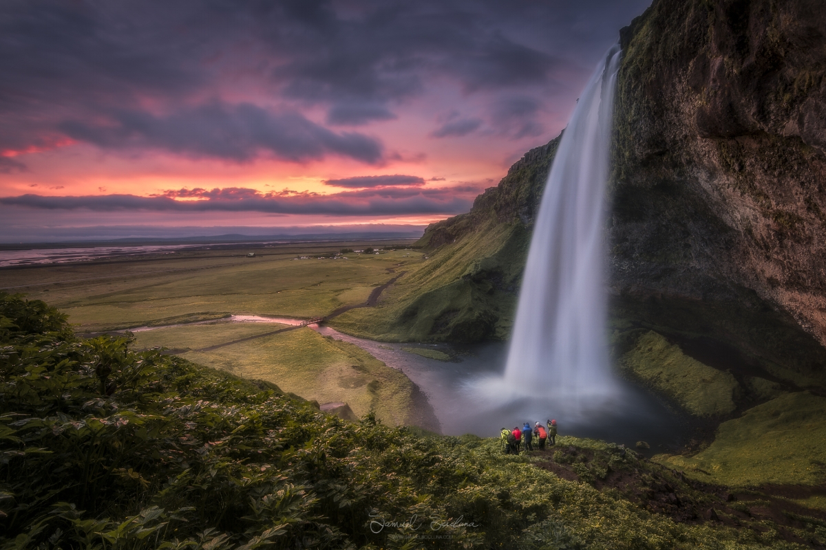 An epic fiery sky just after sunset at Seljalandsfoss waterfall in Iceland.