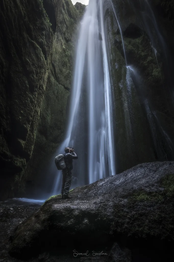 A photographer in the very wet Gljúfrabúi canyon.