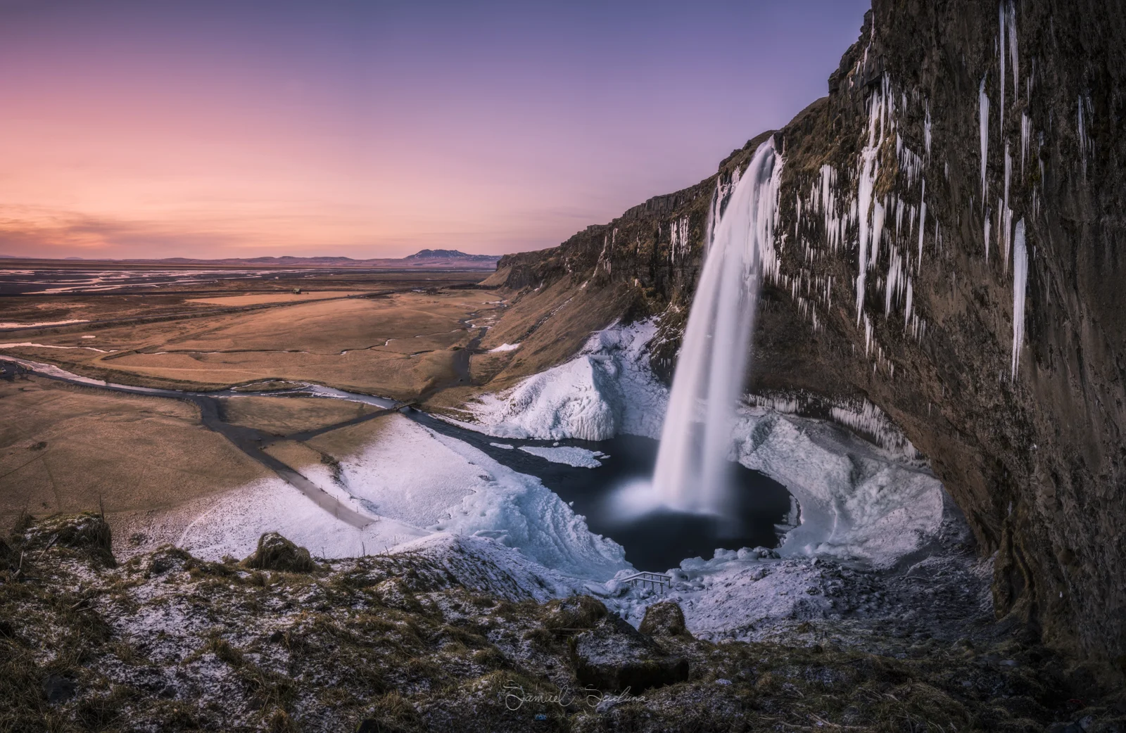 Seljalandsfoss waterfall after sunset. Icicles and frost adorn the great waterfall!
