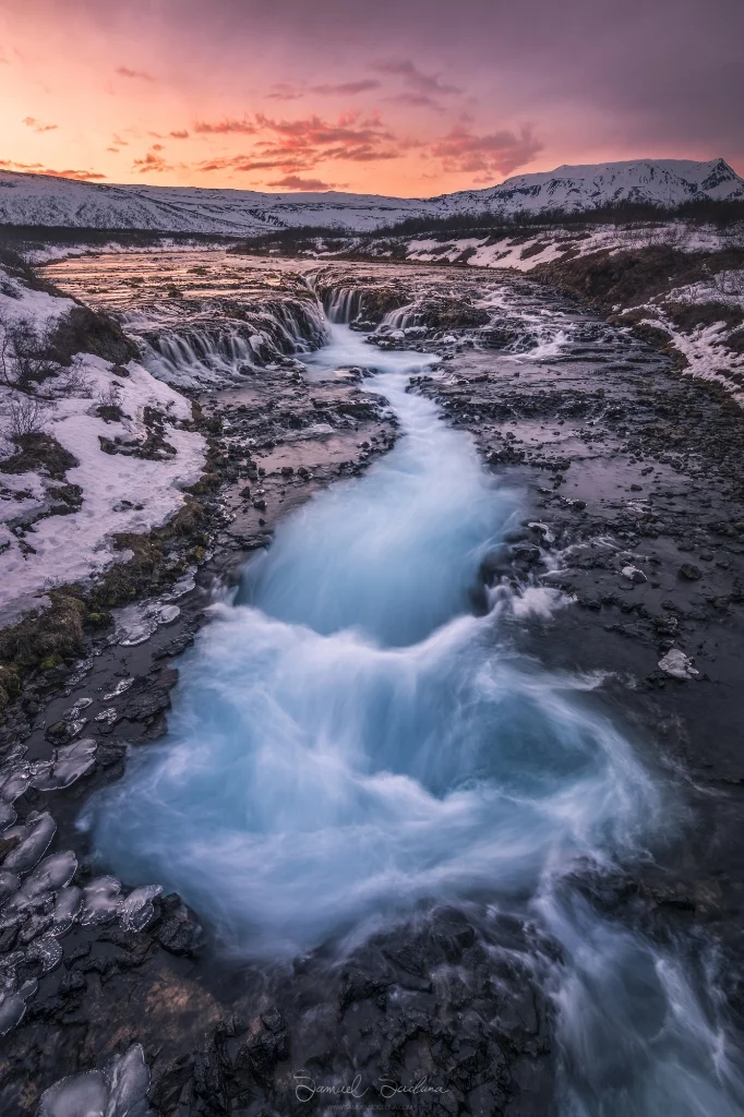 The warm colors of sunset reflect off the snow along the banks of Bruarfoss, the famous blue waterfall!