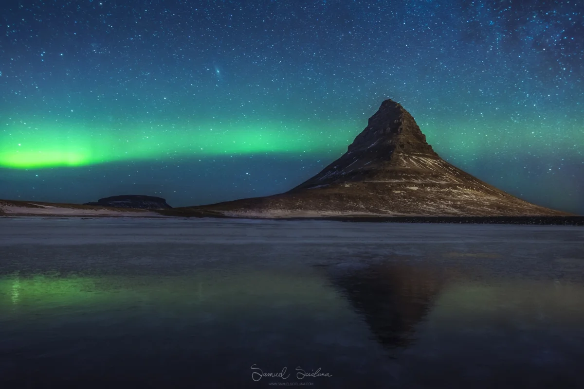 The Northern Lights above Kirkjufell reflecting in a frozen lake.