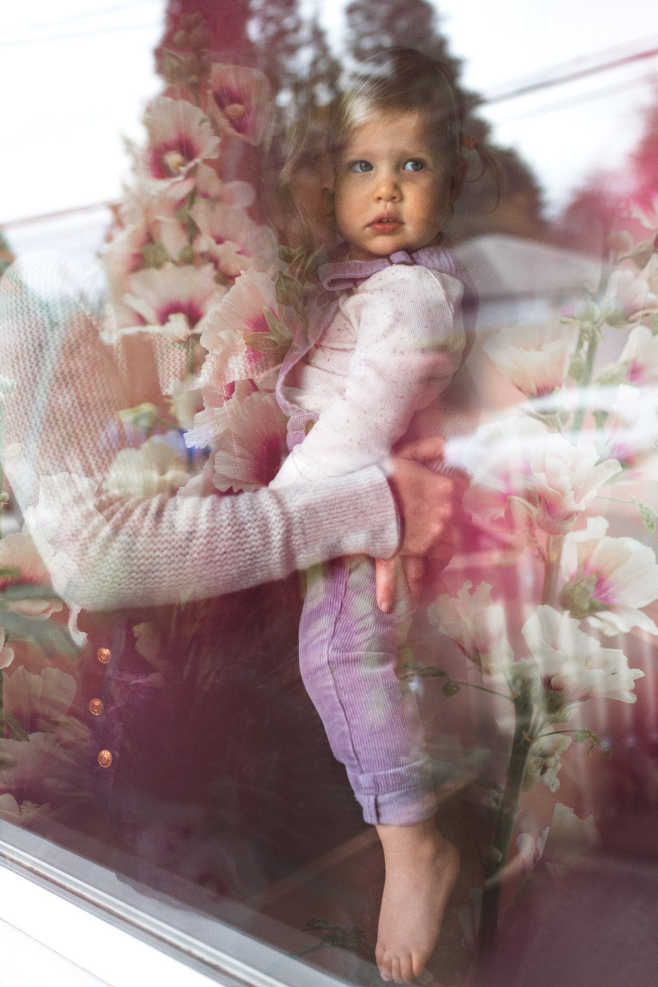 Photo of a mother and daughter through the window of their home in Seattle Wa by Chelsea Macor Photography