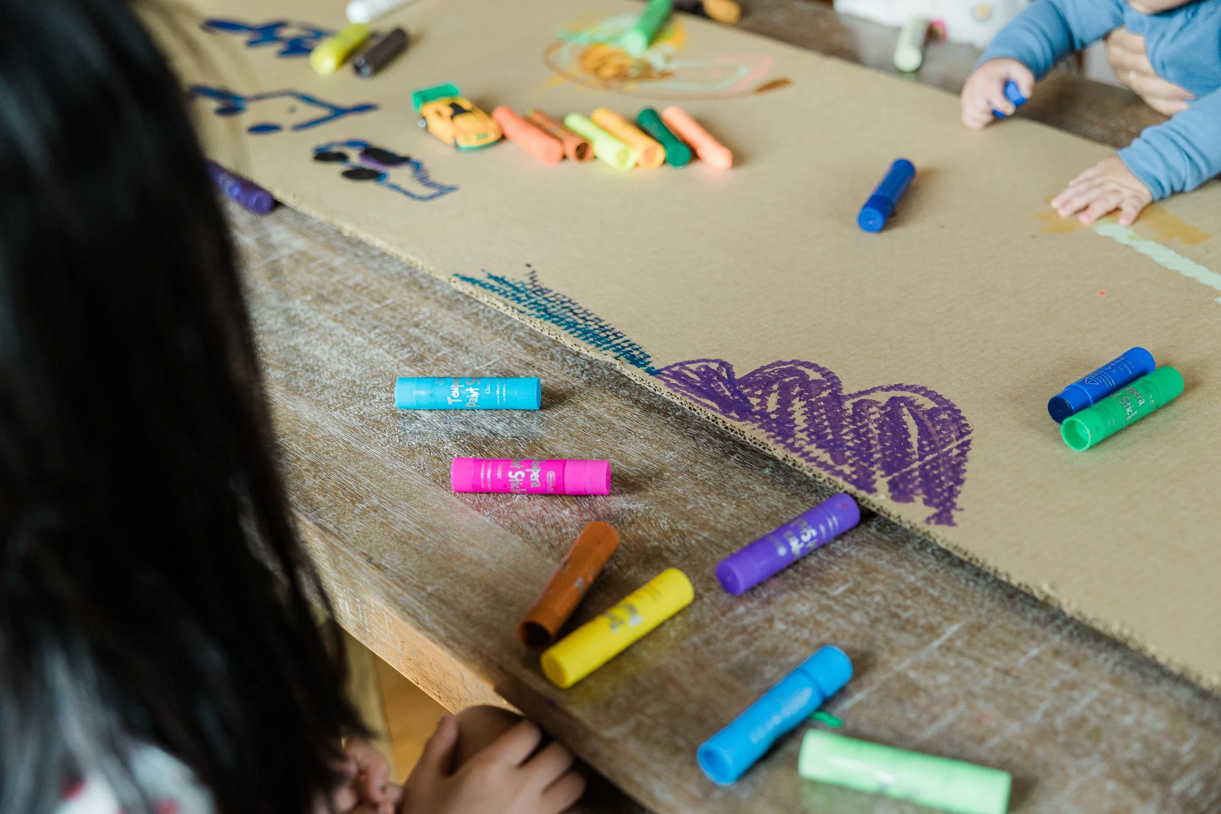 close on cardboard with children's drawings of rainbows and trucks