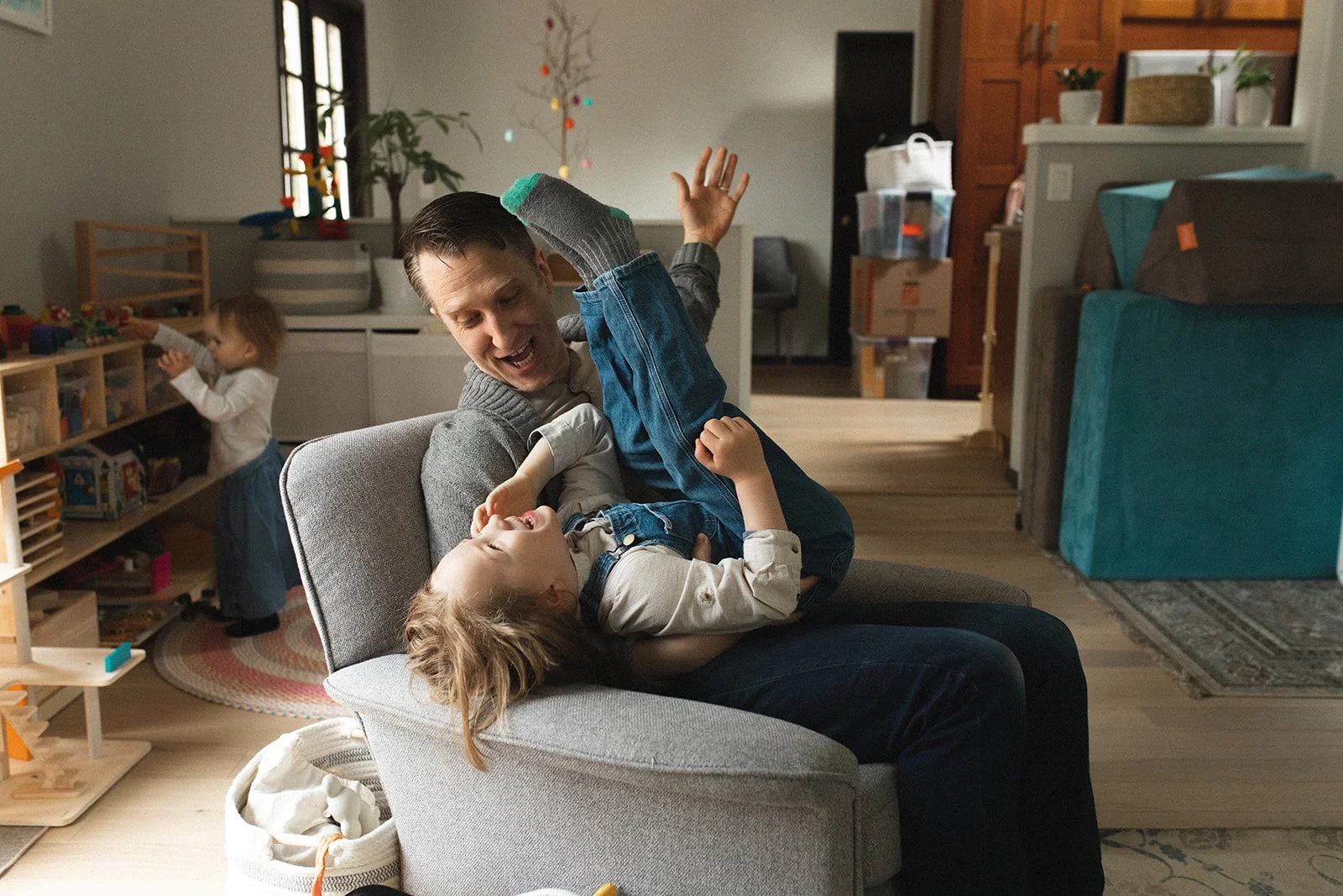 dad holds son on lap while tipping him backwards while they laugh
