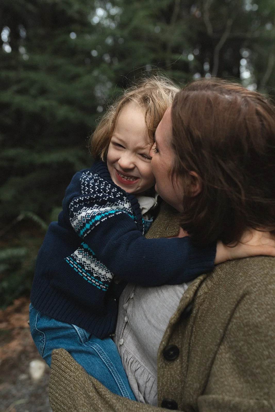 mother nuzzles her sons face while holding him in her arms