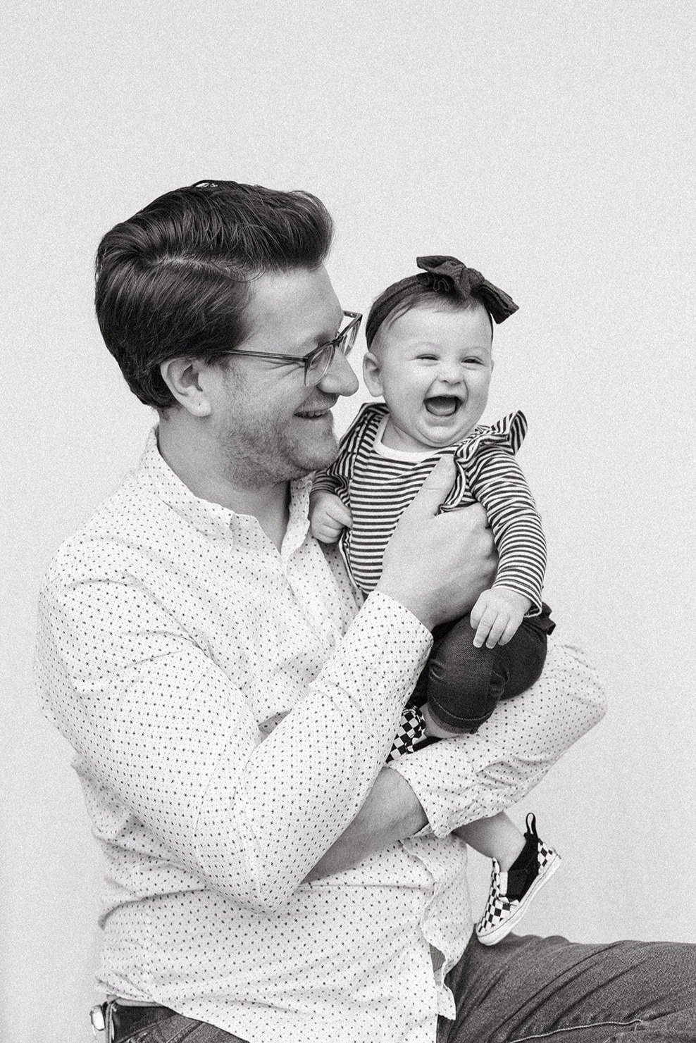 Photograph in black and white of a dad and his happy baby in seattle at village maternity store