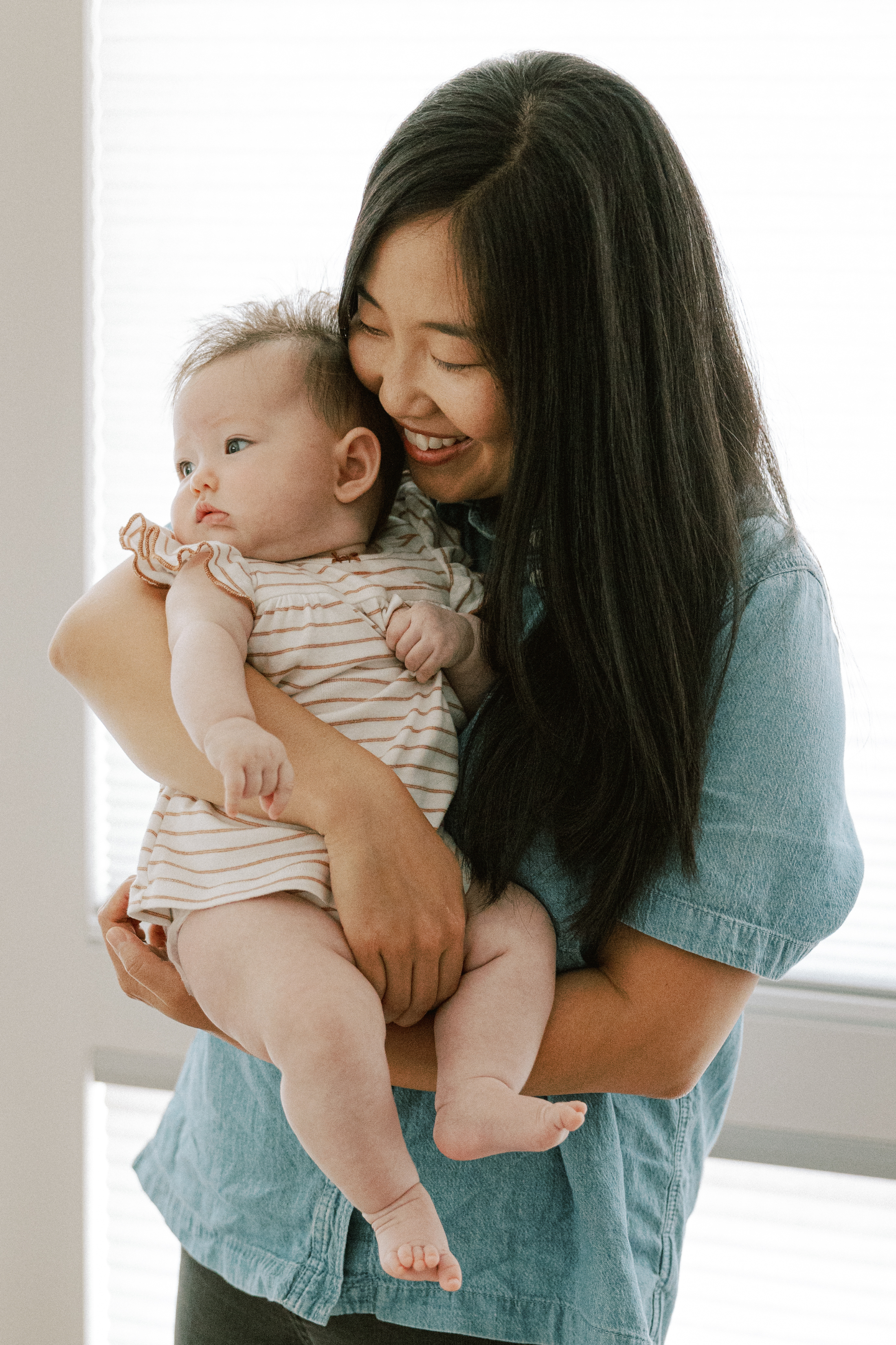 Photograph of a newborn baby and her mom at home during a family photography session in Seattle