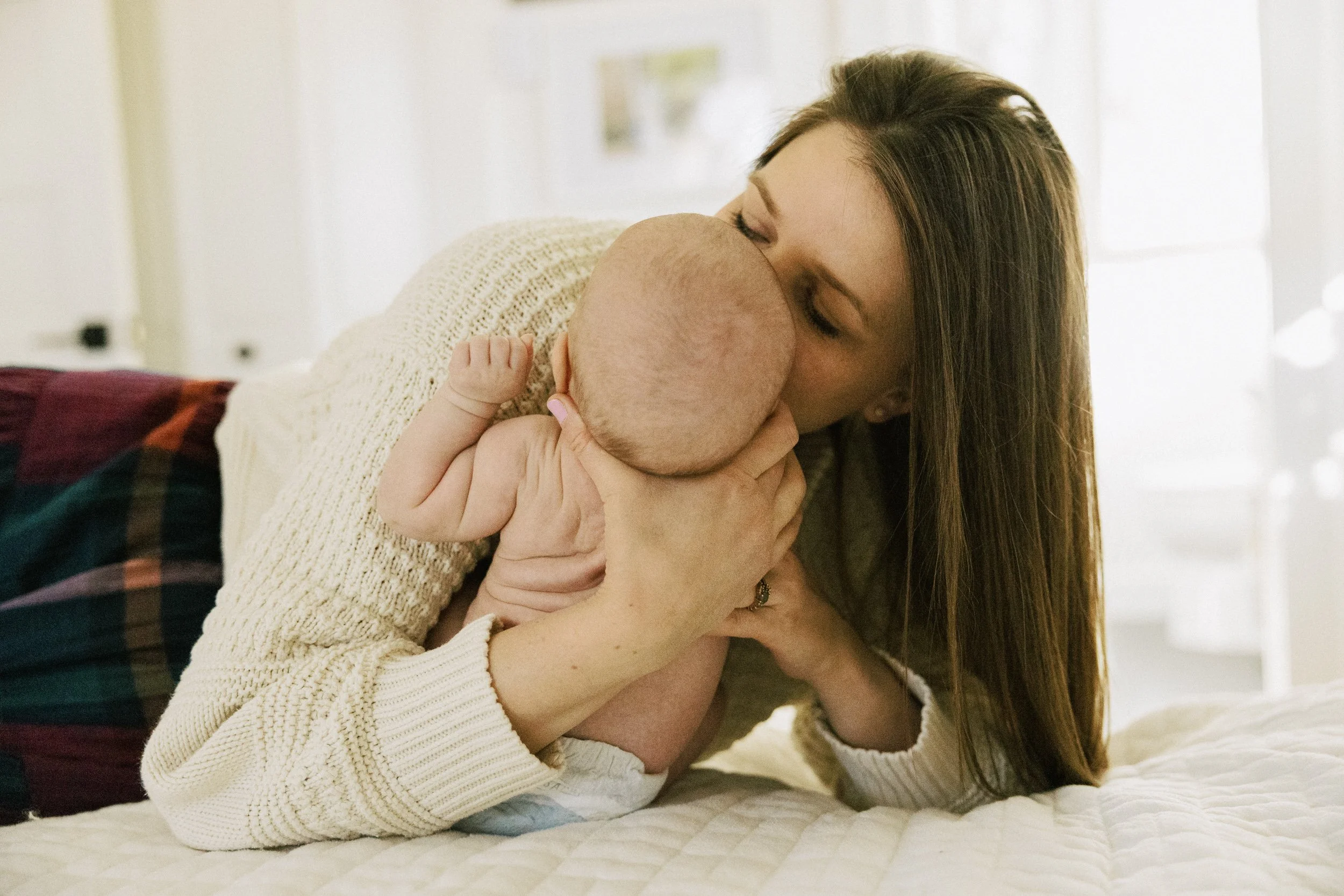 Lifestyle newborn photo of mom holding baby at home
